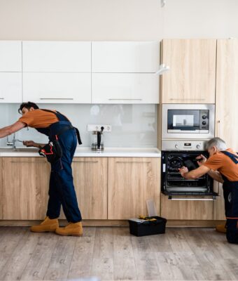 Two,Handymen,,Workers,In,Uniform,Fixing,,Installing,Furniture,And,Equipment